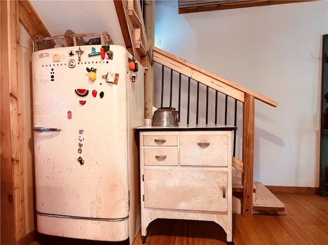 stairway with wood finished floors and baseboards