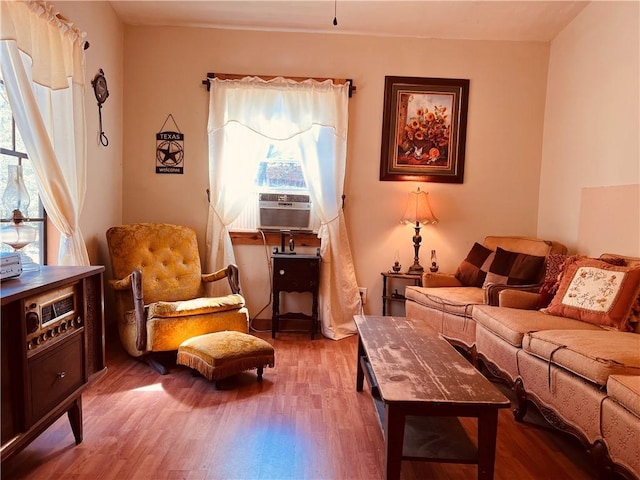 living area with cooling unit and wood finished floors