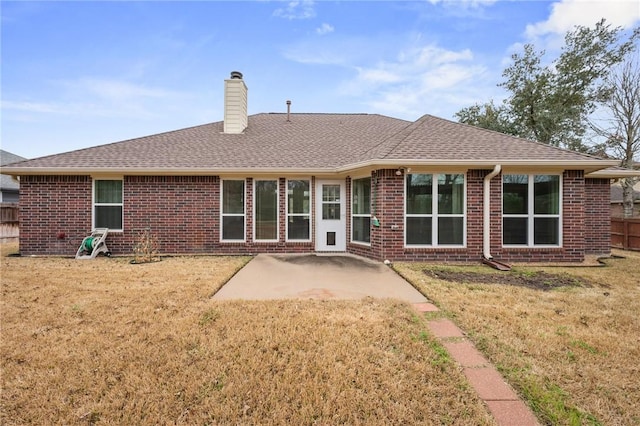 rear view of property with a yard and a patio area