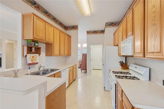 kitchen featuring a sink, white appliances, light floors, light countertops, and a peninsula