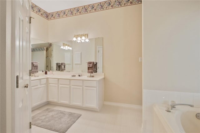 full bath with a sink, a bath, a chandelier, double vanity, and baseboards