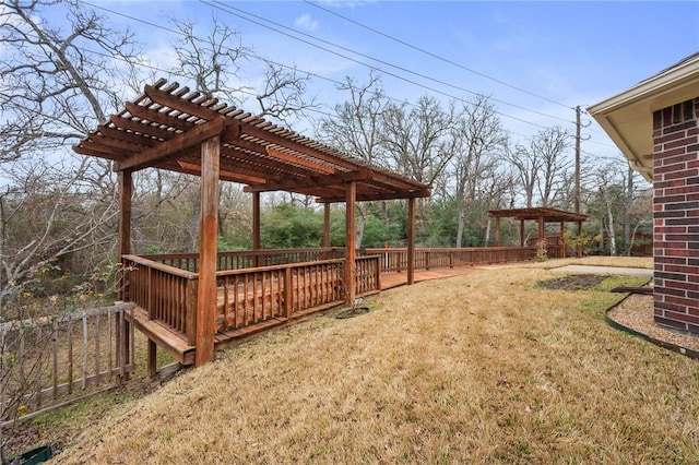view of yard with a wooden deck, a pergola, and fence