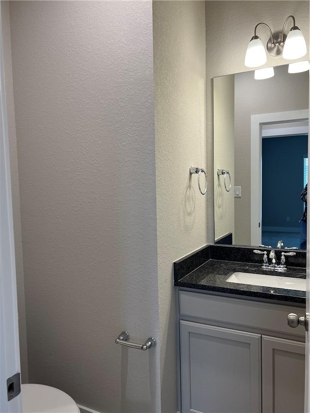 6303 Raleigh Dr, College Station, TX 77845 - half bath with vanity, a textured wall, and toilet