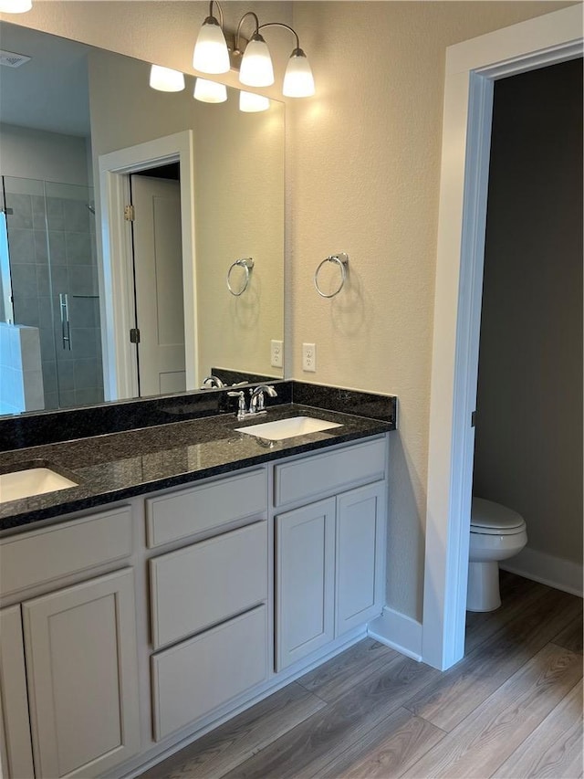6303 Raleigh Dr, College Station, TX 77845 - full bathroom with double vanity, a shower stall, wood finished floors, and baseboards