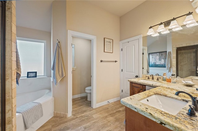 bathroom featuring vanity, hardwood / wood-style flooring, toilet, and a bathtub