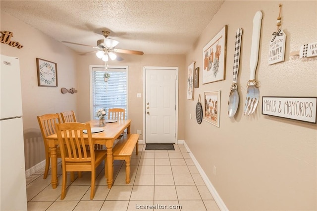 dining room featuring a textured ceiling, ceiling fan, and light tile patterned flooring