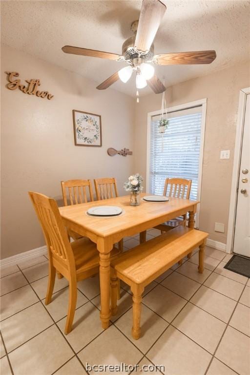 dining room featuring a textured ceiling, ceiling fan, and light tile patterned flooring