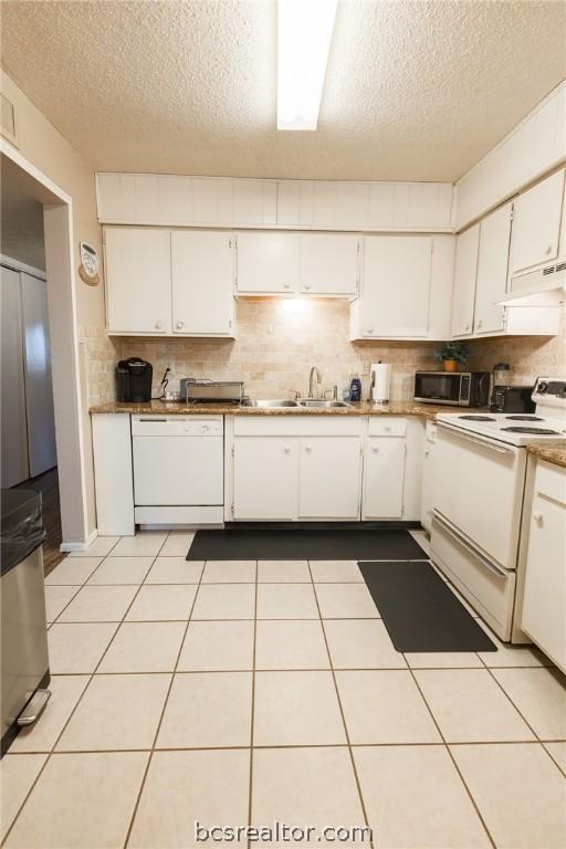 kitchen featuring white cabinets, a textured ceiling, white appliances, and sink