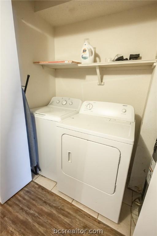 laundry room with wood-type flooring and independent washer and dryer