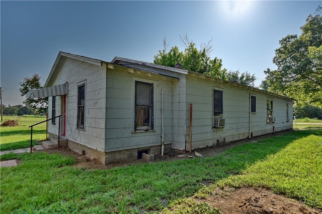 view of side of home with cooling unit and a lawn