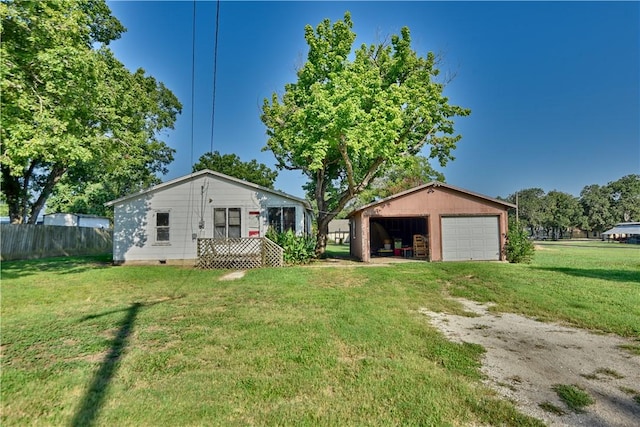 view of front of house with a front lawn, a garage, and an outbuilding