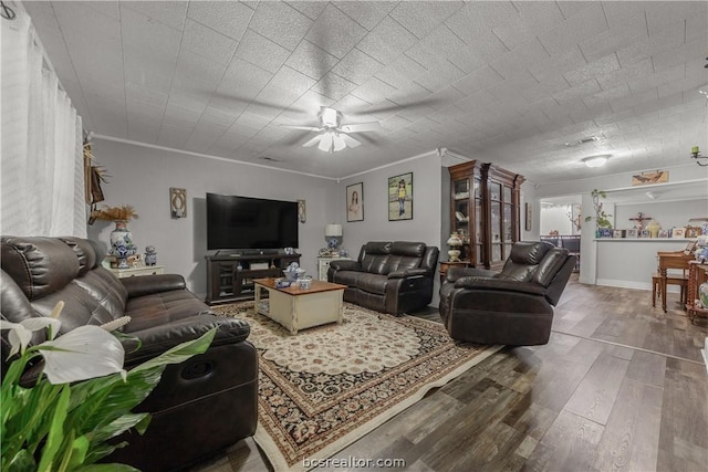 living room with hardwood / wood-style flooring, ceiling fan, and ornamental molding