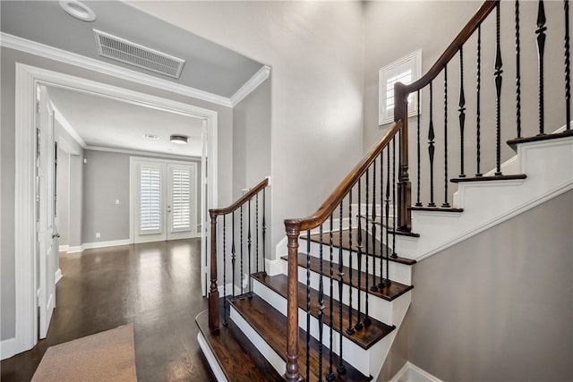 stairway with baseboards, visible vents, wood finished floors, crown molding, and french doors