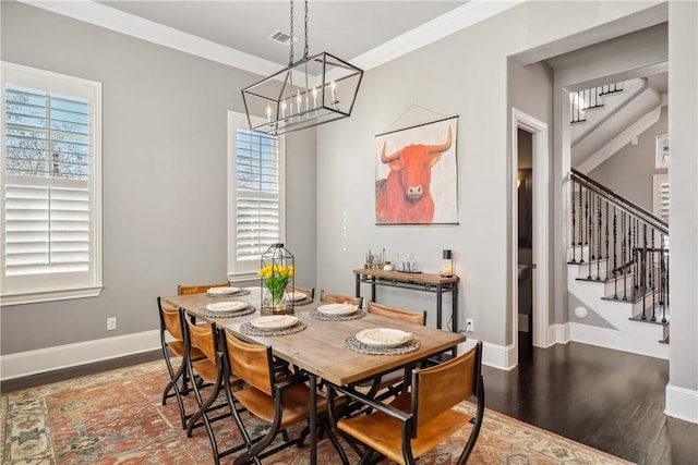 dining area featuring ornamental molding, plenty of natural light, stairs, and wood finished floors