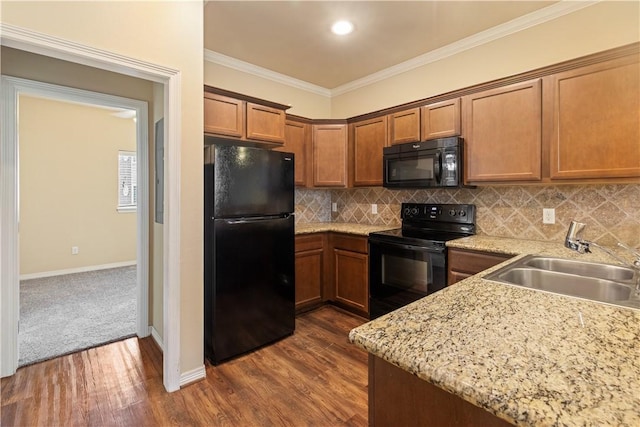 1198 Jones Butler Rd, College Station, TX 77840 - kitchen featuring black appliances, brown cabinets, dark wood-style floors, crown molding, and tasteful backsplash