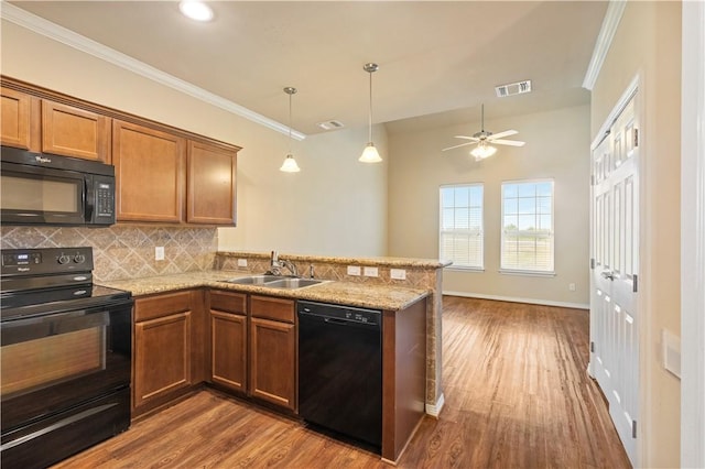 1198 Jones Butler Rd, College Station, TX 77840 - kitchen featuring black appliances, a peninsula, backsplash, dark wood-style flooring, and brown cabinets