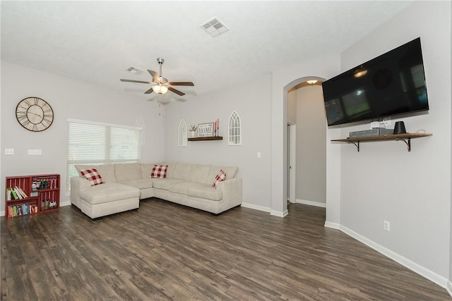 living room featuring visible vents, arched walkways, baseboards, and wood finished floors