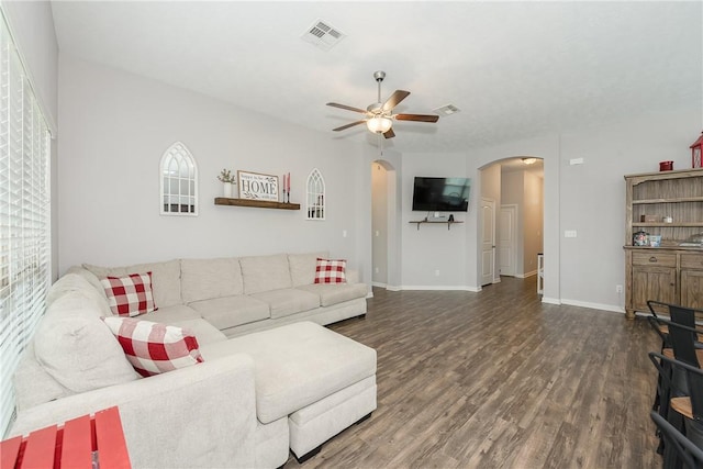 living room featuring visible vents, a ceiling fan, wood finished floors, arched walkways, and baseboards