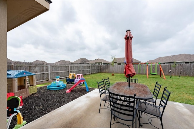 view of patio / terrace featuring a playground, outdoor dining area, and a fenced backyard