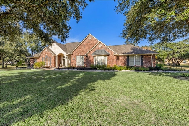 view of front of home featuring brick siding and a front lawn