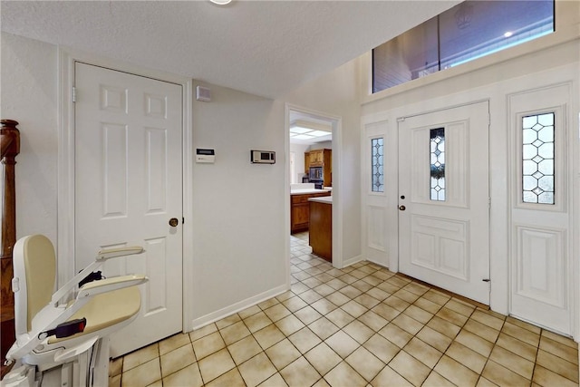 tiled entryway with a textured ceiling