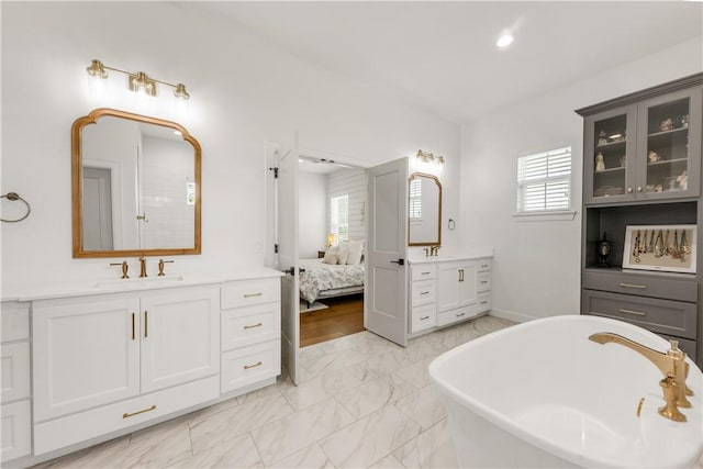 4435 Williams Lake Dr, College Station, TX 77845 - bathroom featuring two vanities, a soaking tub, connected bathroom, and a sink