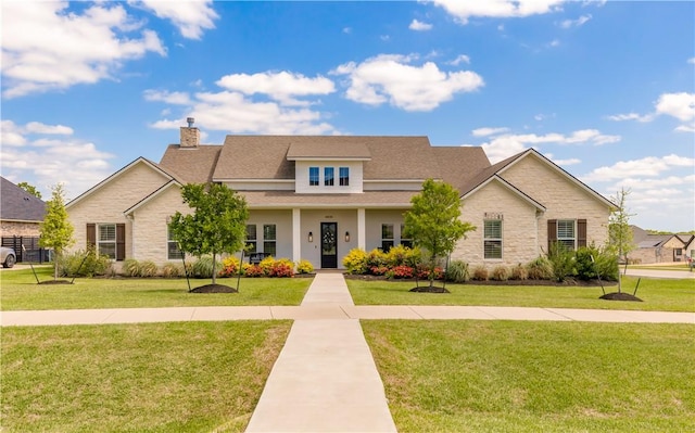 4435 Williams Lake Dr, College Station, TX 77845 - view of front of property featuring a chimney, a front lawn, stone siding, and a shingled roof