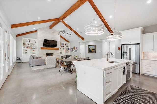 11188 Riley Green Rd, Franklin, TX 77856 - kitchen featuring stainless steel appliances, a fireplace, an island with sink, finished concrete floors, and hanging light fixtures