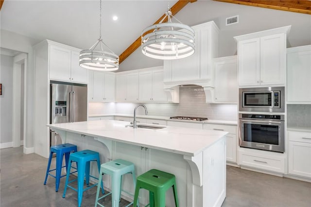 11188 Riley Green Rd, Franklin, TX 77856 - kitchen featuring stainless steel appliances, concrete flooring, decorative backsplash, a breakfast bar, and white cabinets