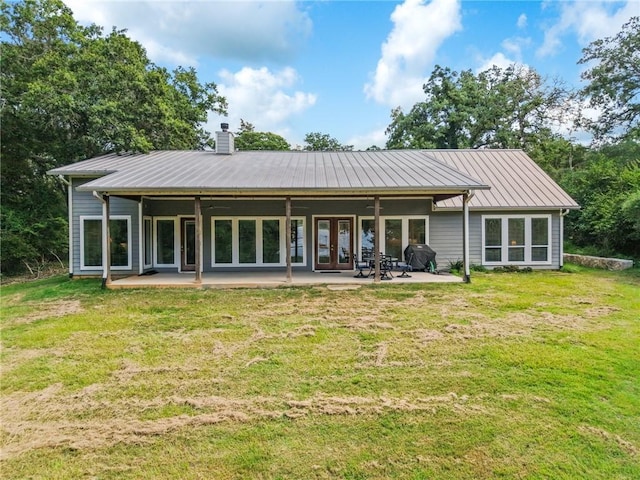 11188 Riley Green Rd, Franklin, TX 77856 - back of property with a patio area, a chimney, a yard, french doors, and a metal roof