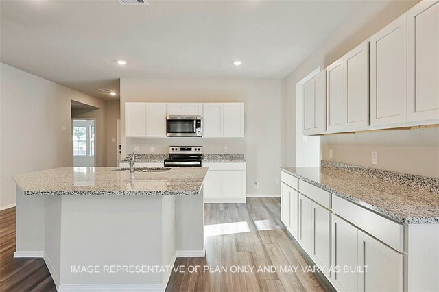 205 Rockbridge Dr, Huntsville, TX 77340 - kitchen with stainless steel appliances, light wood finished floors, white cabinetry, light stone countertops, and recessed lighting