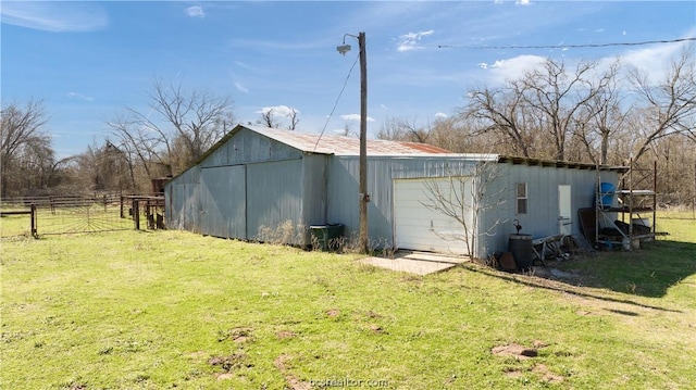 view of side of home featuring a lawn and an outdoor structure