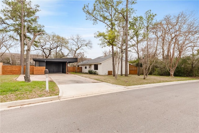 ranch-style home with a carport and a front lawn