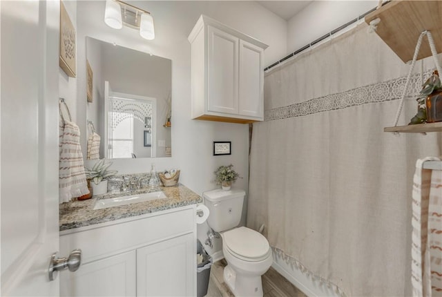 bathroom with vanity, curtained shower, and toilet