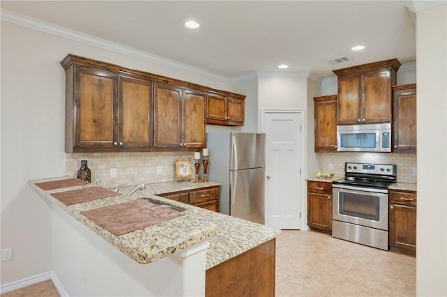 3609 Haverford Rd, College Station, TX 77845 - kitchen featuring stainless steel appliances, tasteful backsplash, a peninsula, ornamental molding, and recessed lighting