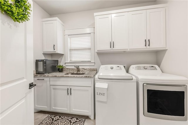 washroom with sink, cabinets, and washer and dryer