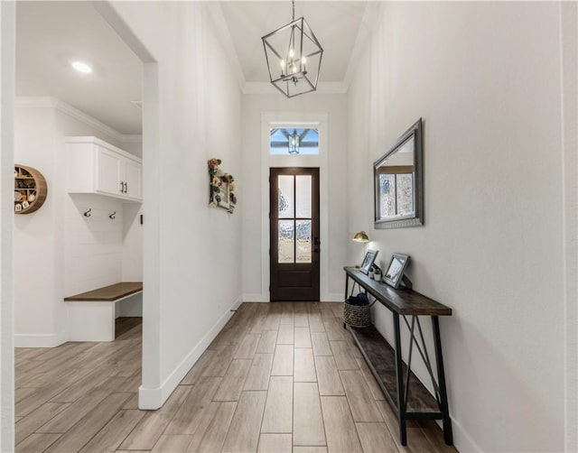 foyer featuring crown molding and a notable chandelier