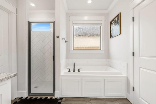 bathroom featuring crown molding and separate shower and tub