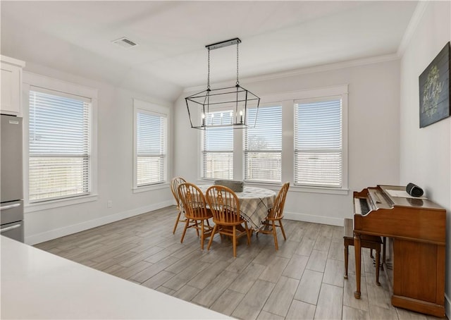 dining room featuring ornamental molding, an inviting chandelier, and light hardwood / wood-style flooring