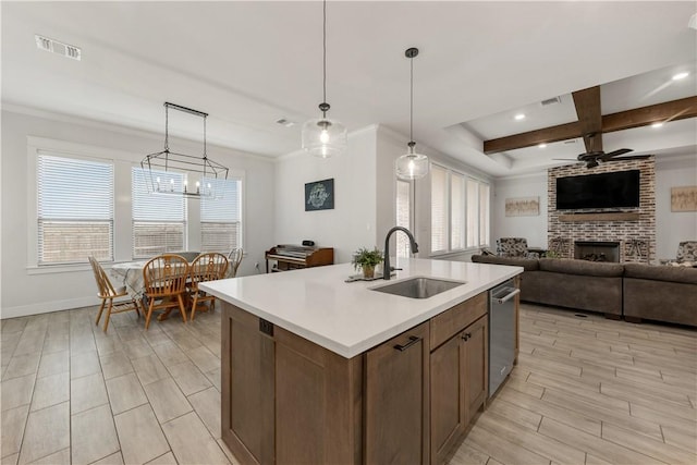 kitchen featuring a center island with sink, sink, pendant lighting, and ceiling fan