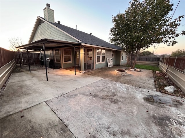 back house at dusk with a patio and an outdoor fire pit