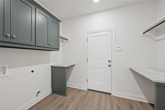 laundry area with electric dryer hookup, cabinets, light hardwood / wood-style flooring, and washer hookup