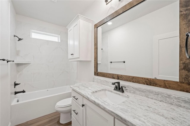 full bathroom with tiled shower / bath combo, hardwood / wood-style flooring, toilet, and vanity