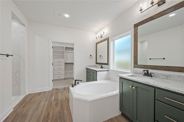 bathroom featuring hardwood / wood-style floors, independent shower and bath, and vanity