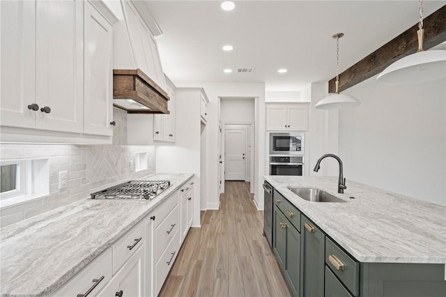 kitchen with sink, white cabinetry, and hanging light fixtures