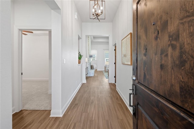 hall with hardwood / wood-style floors and a notable chandelier