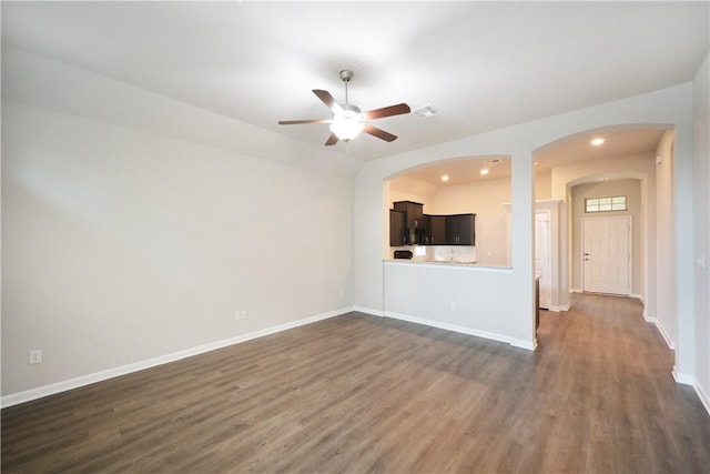 2135 Dumfries Dr, Bryan, TX 77807 - unfurnished living room with dark wood-type flooring, ceiling fan, baseboards, arched walkways, and recessed lighting