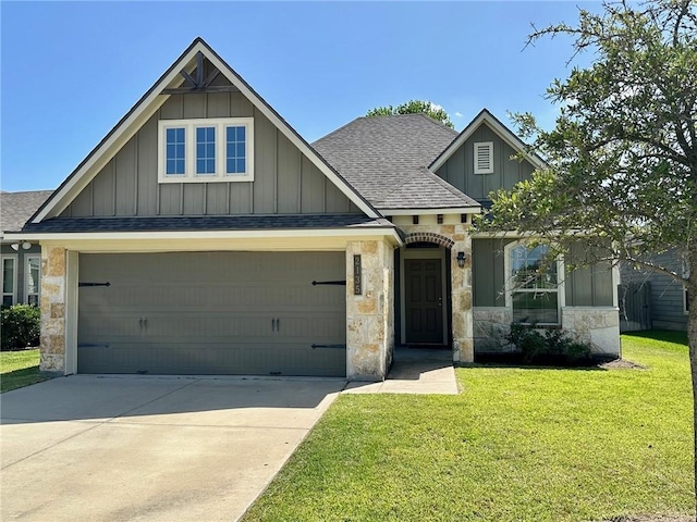 2135 Dumfries Dr, Bryan, TX 77807 - view of front of house featuring roof with shingles, board and batten siding, a front yard, stone siding, and concrete driveway
