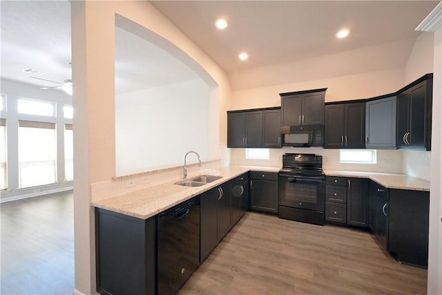 2135 Dumfries Dr, Bryan, TX 77807 - kitchen with black appliances, a sink, light wood-style floors, light stone counters, and a ceiling fan