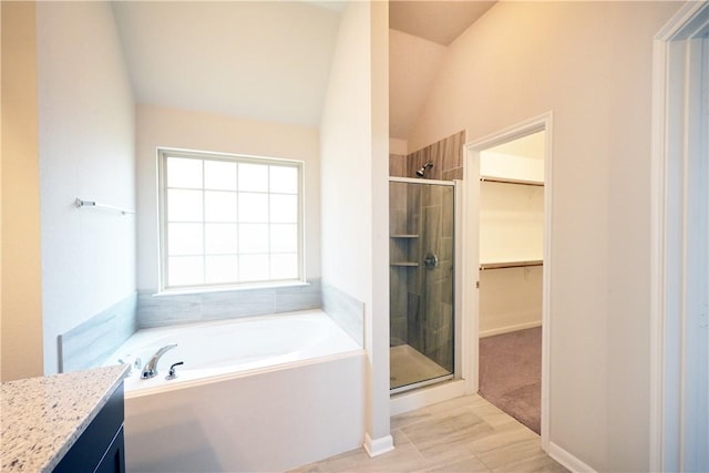2135 Dumfries Dr, Bryan, TX 77807 - full bathroom featuring a bath, a stall shower, vanity, a spacious closet, and lofted ceiling